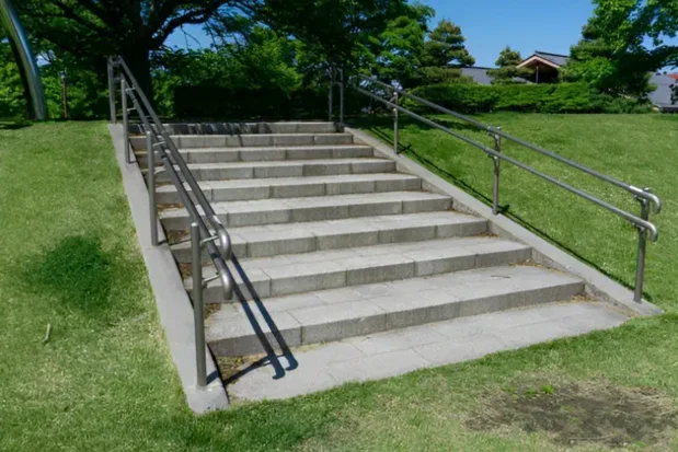 Exterior concrete staircase and landing with metal handrails